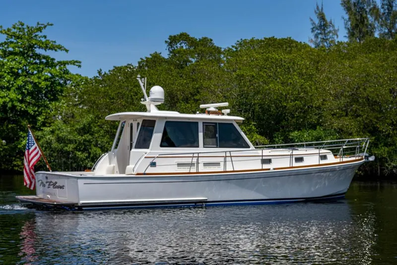 Slide: The Image of 2007 Grand Banks 43 Eastbay SX on calm water, surrounded by lush greenery. - 6