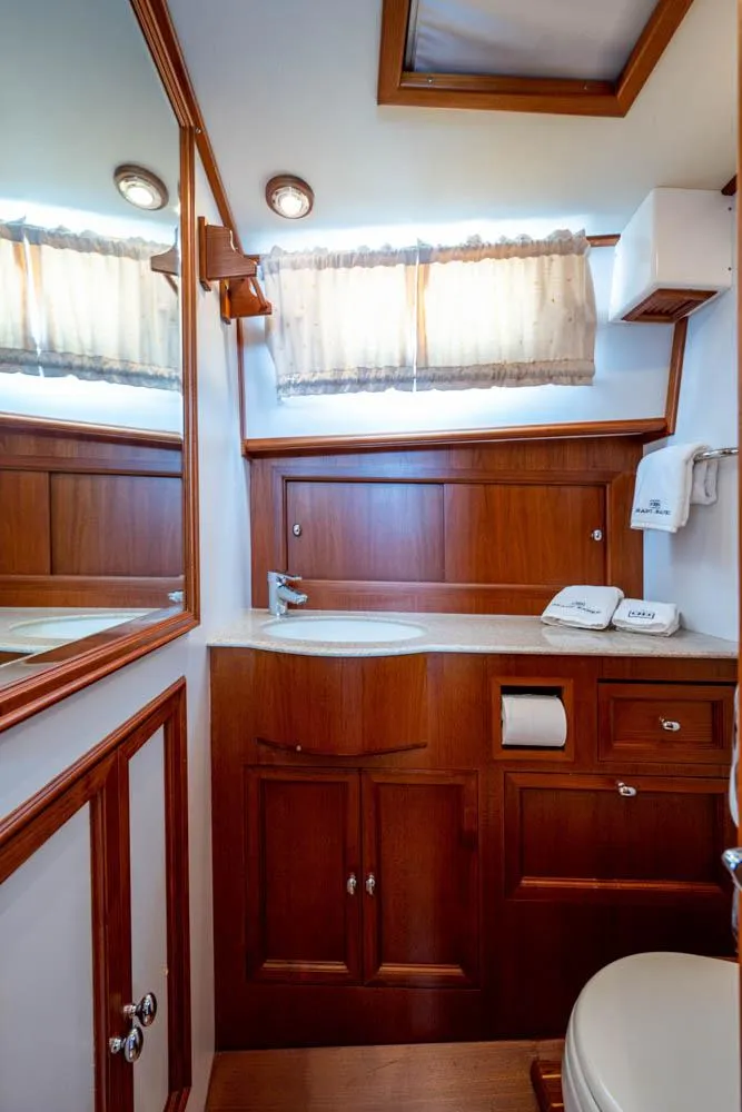 Slide: The Image of The image shows an elegant bathroom with wood paneling and modern fixtures on a yacht. - 45