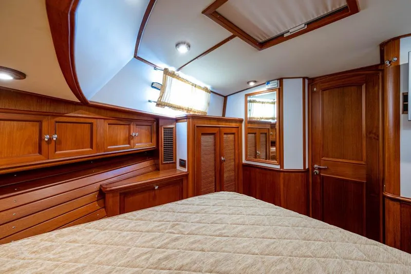 Slide: The Image of The cabin of the 2007 Grand Banks 43 Eastbay SX features cozy wood paneling and a large bed. - 38
