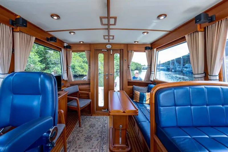 Slide: The Image of Interior of a 2007 Grand Banks 43 Eastbay SX with blue seating and wood finishes. - 31