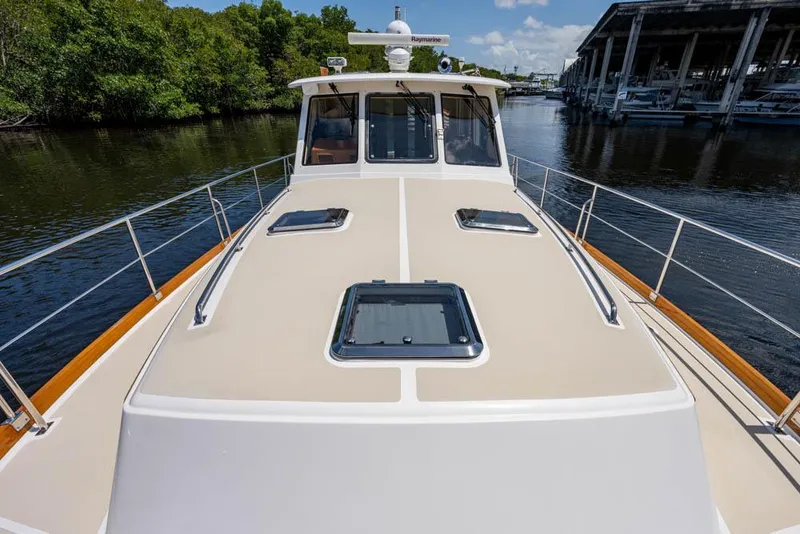 Slide: The Image of 2007 Grand Banks 43 Eastbay SX on a calm river with lush greenery in the background. - 16