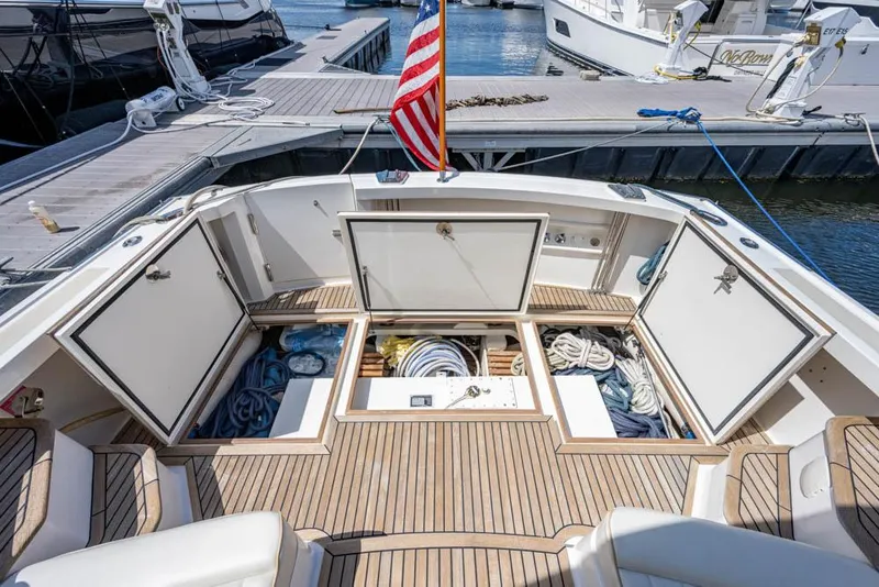 Slide: The Image of The image shows the cockpit of a 2007 Grand Banks 43 Eastbay SX with open storage hatches and ropes. - 19