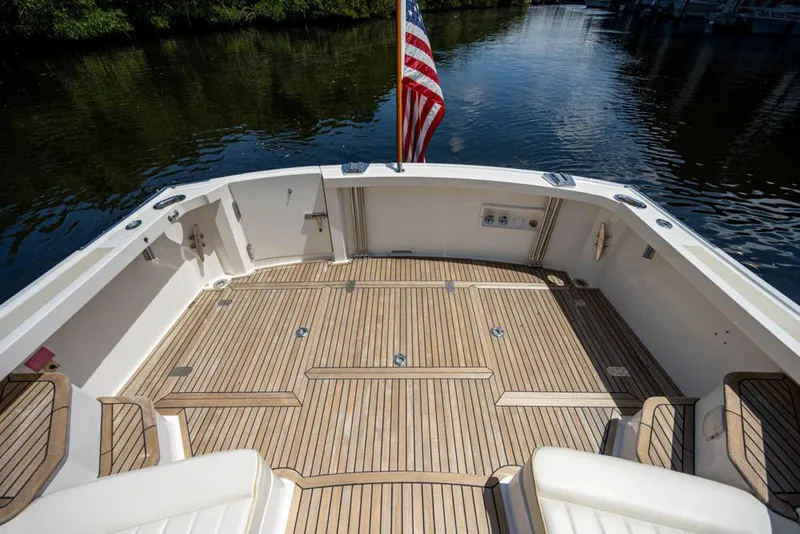 Slide: The Image of The image shows the spacious aft deck of a 2007 Grand Banks 43 Eastbay SX with teak flooring. - 18