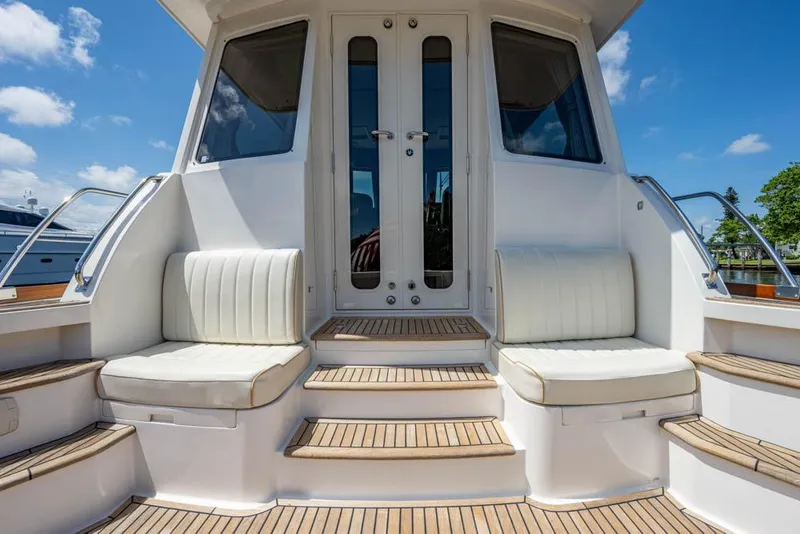 Slide: The Image of Grand Banks 43 Eastbay SX 2007 with white seats and wooden flooring, outdoors under blue sky. - 25