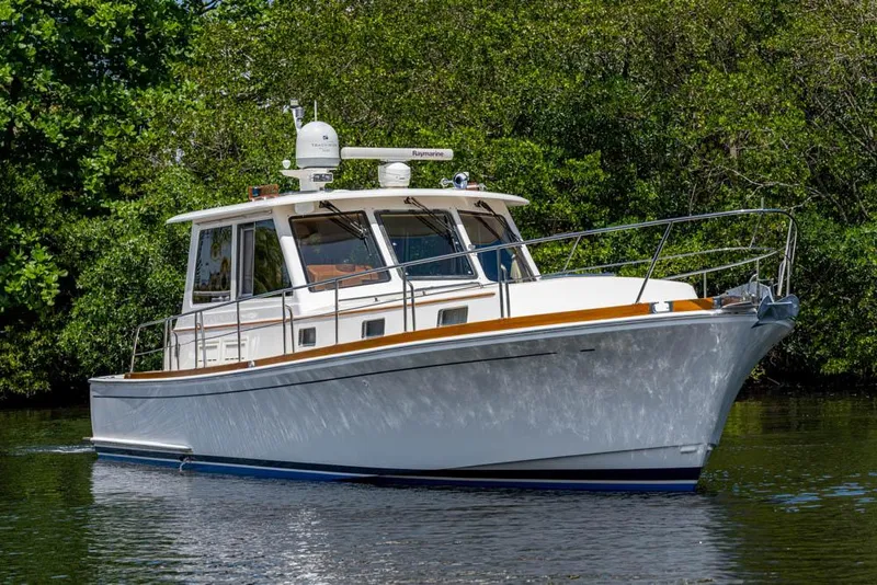 Slide: The Image of 2007 Grand Banks 43 Eastbay SX on calm water with a green backdrop. - 10