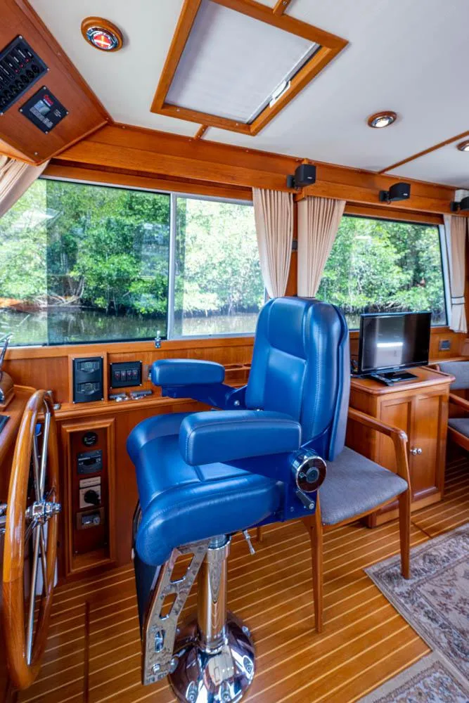 Slide: The Image of Interior of the 2007 Grand Banks 43 Eastbay SX with blue captain's chair and wooden flooring. - 33