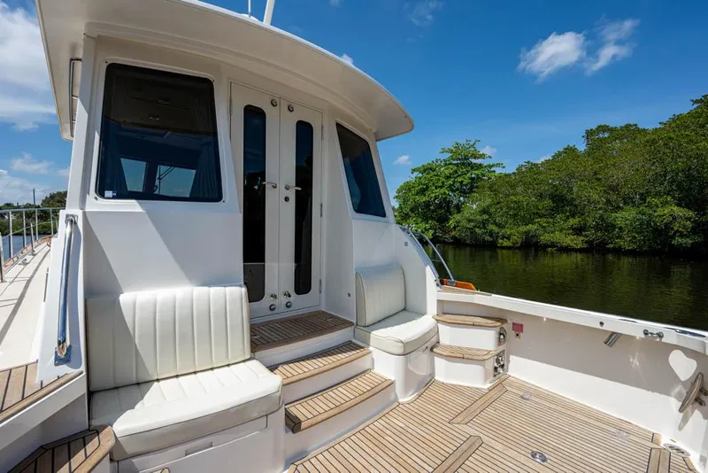 Slide: The Image of The image shows the stern of a 2007 Grand Banks 43 Eastbay SX with seating and wooden decking. - 23