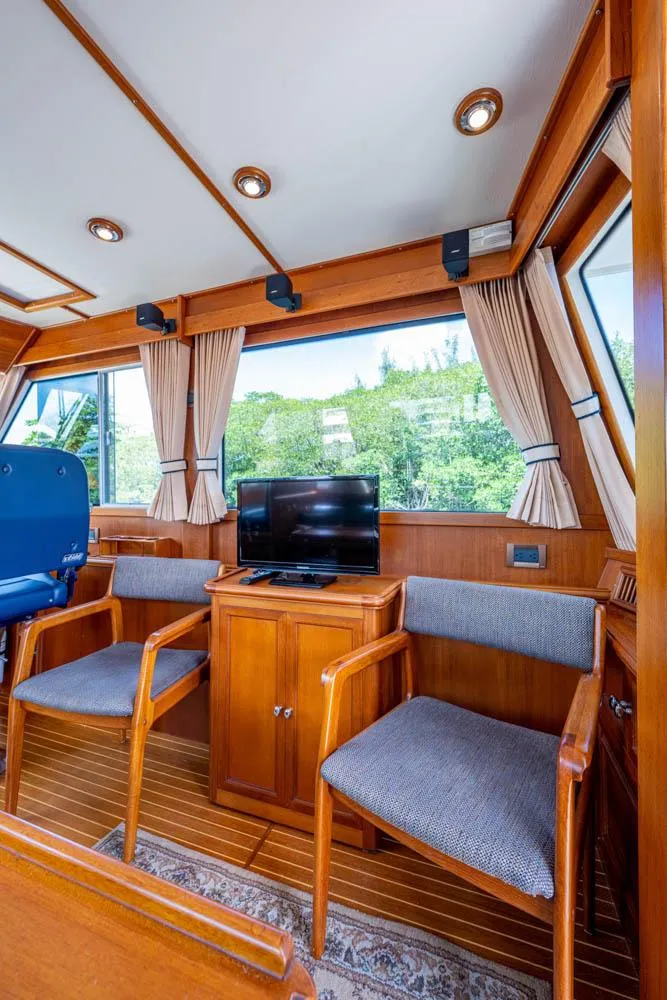 Slide: The Image of Interior of the 2007 Grand Banks 43 Eastbay SX with wooden furniture and a TV. - 29