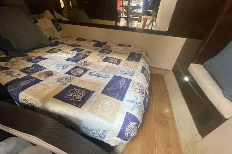 Slide: The Image of Cozy cabin interior of 2018 Sea Ray Sundancer 350 Coupe with nautical-themed bedding. - 17