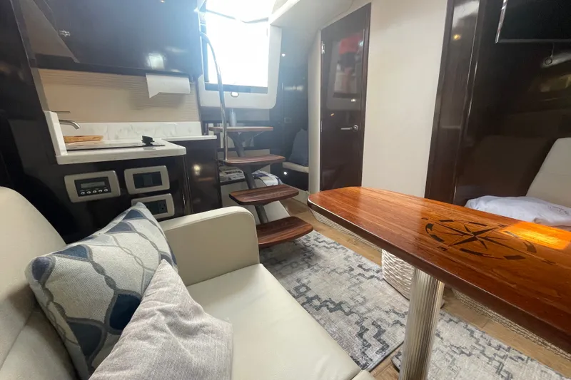 Slide: The Image of Interior of 2018 Sea Ray Sundancer 350 Coupe with modern furnishings and wooden accents. - 16