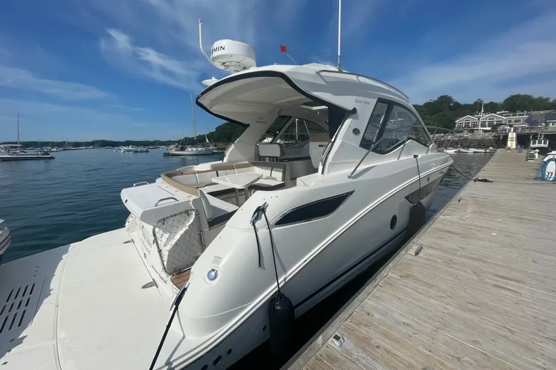 Slide: The Image of 2018 Sea Ray Sundancer 350 Coupe docked at a marina under a clear blue sky. - 3