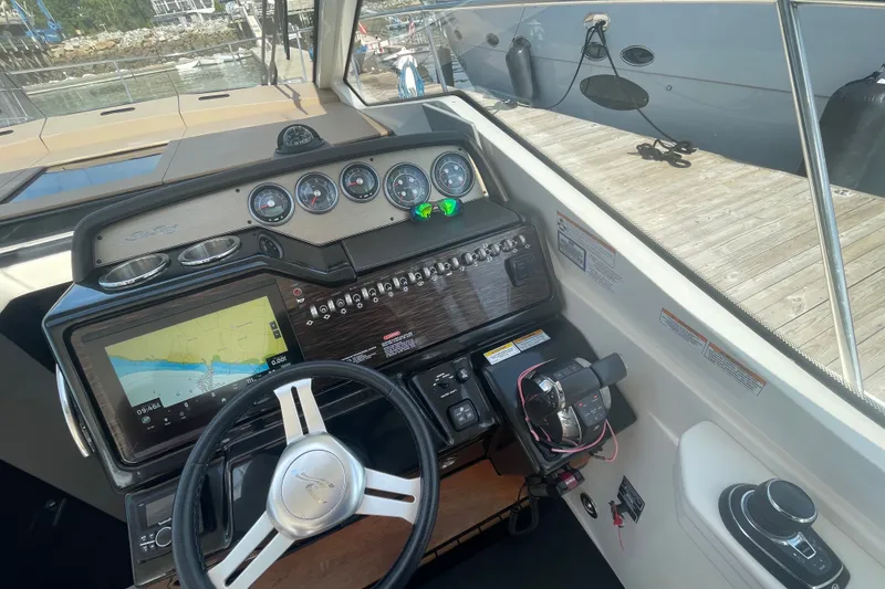 Slide: The Image of 2018 Sea Ray Sundancer 350 Coupe helm with navigation display and controls. - 10