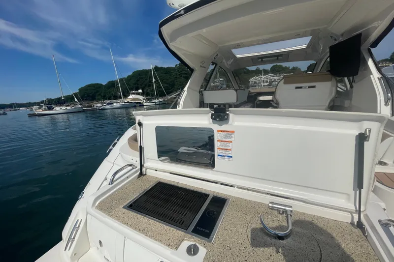 Slide: The Image of 2018 Sea Ray Sundancer 350 Coupe with outdoor kitchenette, docked in a scenic marina. - 6