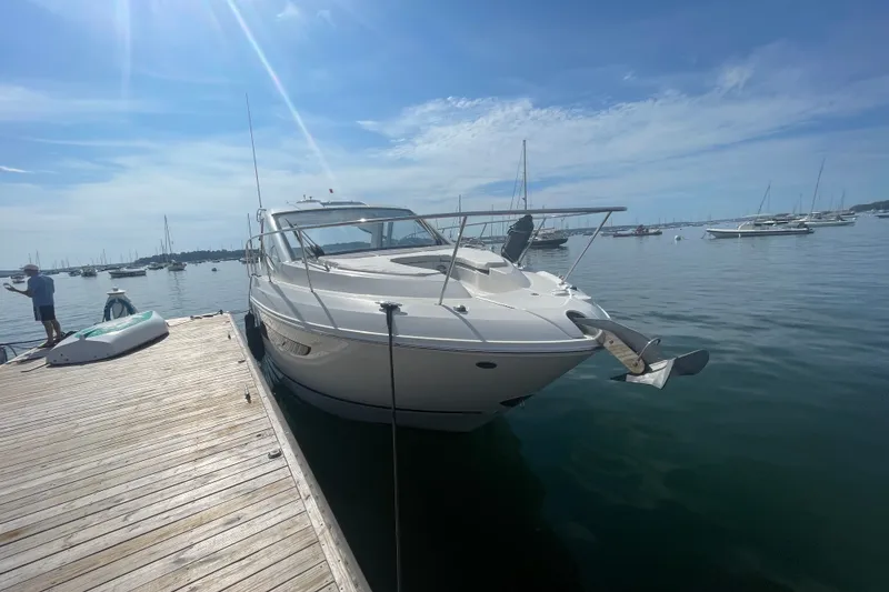 Slide: The Image of 2018 Sea Ray Sundancer 350 Coupe docked at a marina on a sunny day. - 2