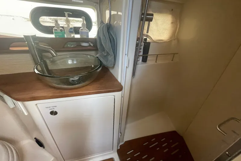 Slide: The Image of 2018 Sea Ray Sundancer 350 Coupe bathroom with glass sink and shower area. - 23
