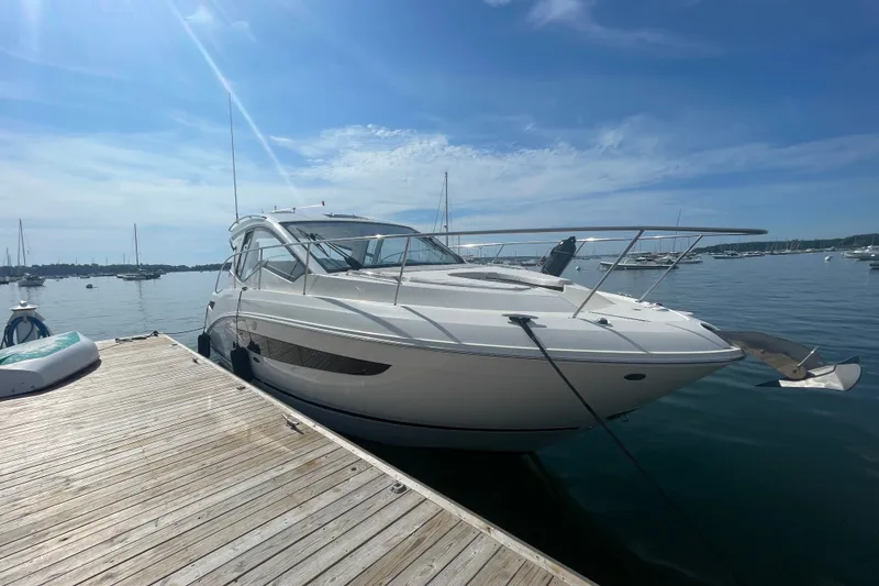 The Image of 2018 Sea Ray Sundancer 350 Coupe docked at a marina under a clear blue sky. - 0