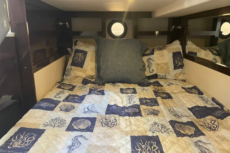 Slide: The Image of Cozy cabin bed in 2018 Sea Ray Sundancer 350 Coupe with nautical-themed bedding. - 19