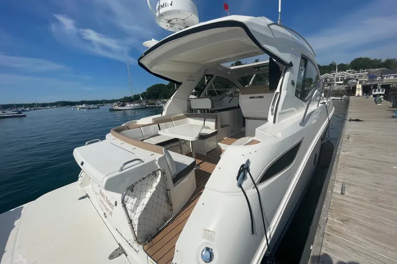Slide: The Image of 2018 Sea Ray Sundancer 350 Coupe docked, showcasing sleek design and spacious deck. - 5