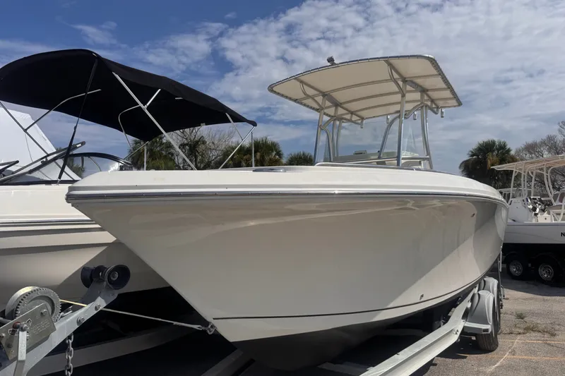 Slide: The Image of 2022 Sailfish 242 CC boat on trailer under blue sky. - 2