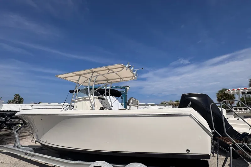 Slide: The Image of 2022 Sailfish 242 CC boat on trailer under clear blue sky. - 3