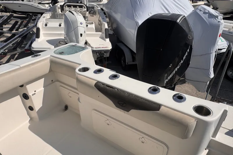 Slide: The Image of 2022 Sailfish 242 CC boat with Mercury engine, featuring rod holders and storage compartments. - 12