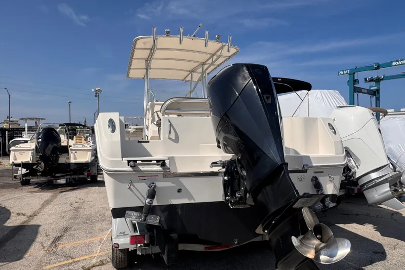 Slide: The Image of 2022 Sailfish 242 CC boat with outboard motor in a marina setting. - 4