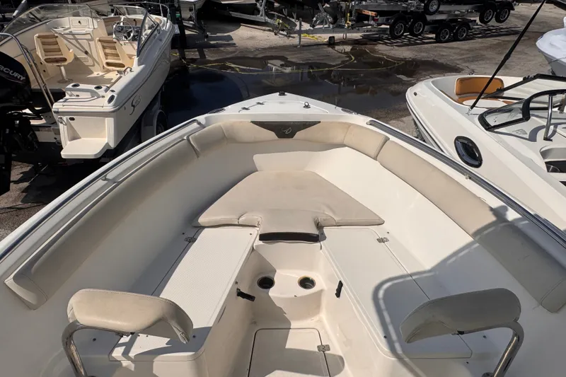 Slide: The Image of 2022 Sailfish 242 CC boat interior with cushioned seating and storage compartments. - 11