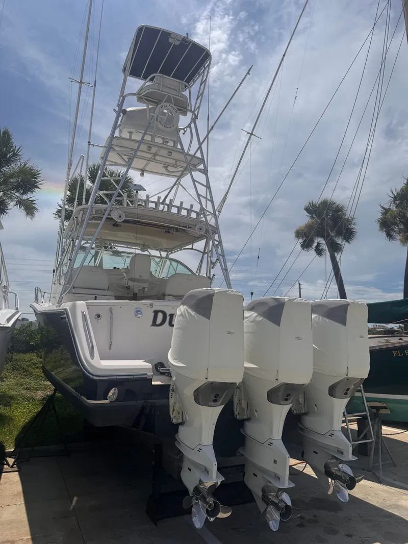 The Image of A 2005 Grady-White 360 boat with three outboard engines, parked on a dry dock. - 0