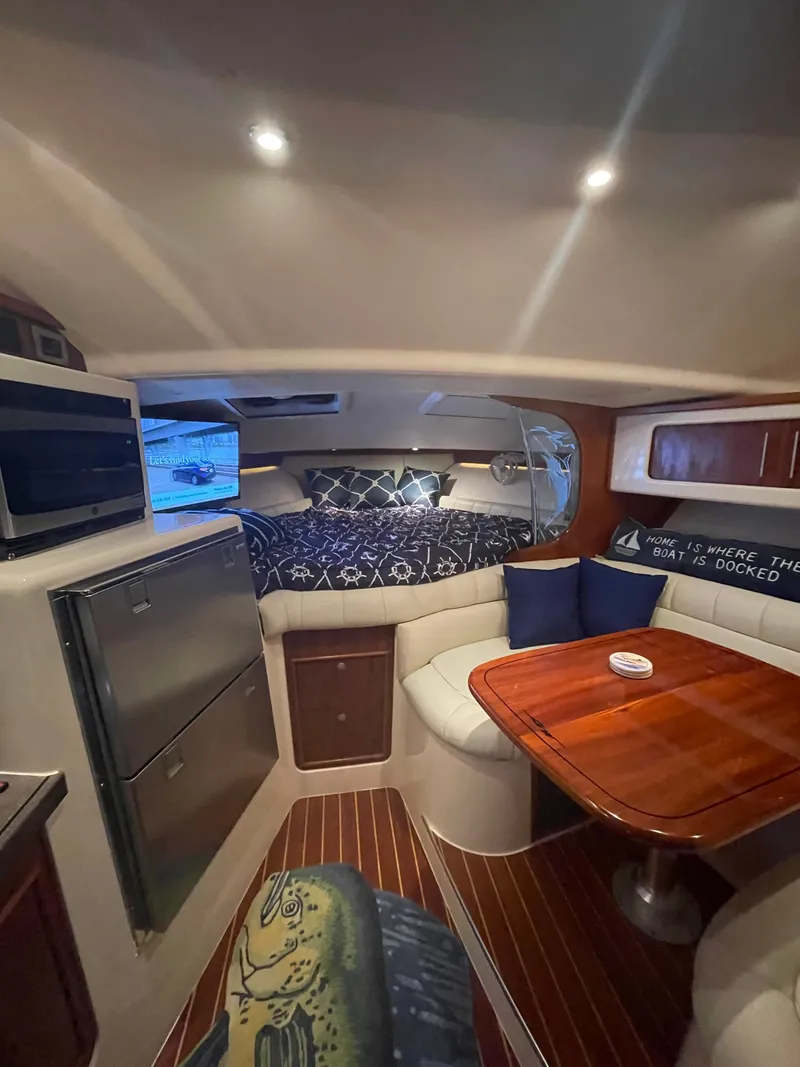 Slide: The Image of The cabin of a 2005 Grady-White Express 360 with a cozy seating area and bed. - 5