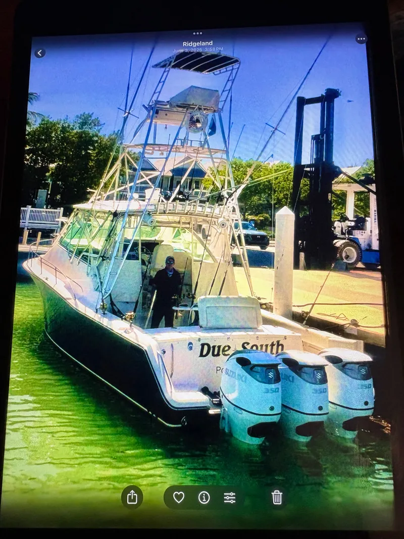 Slide: The Image of A 2005 Grady-White Express 360 boat docked. It features three outboard engines. - 2