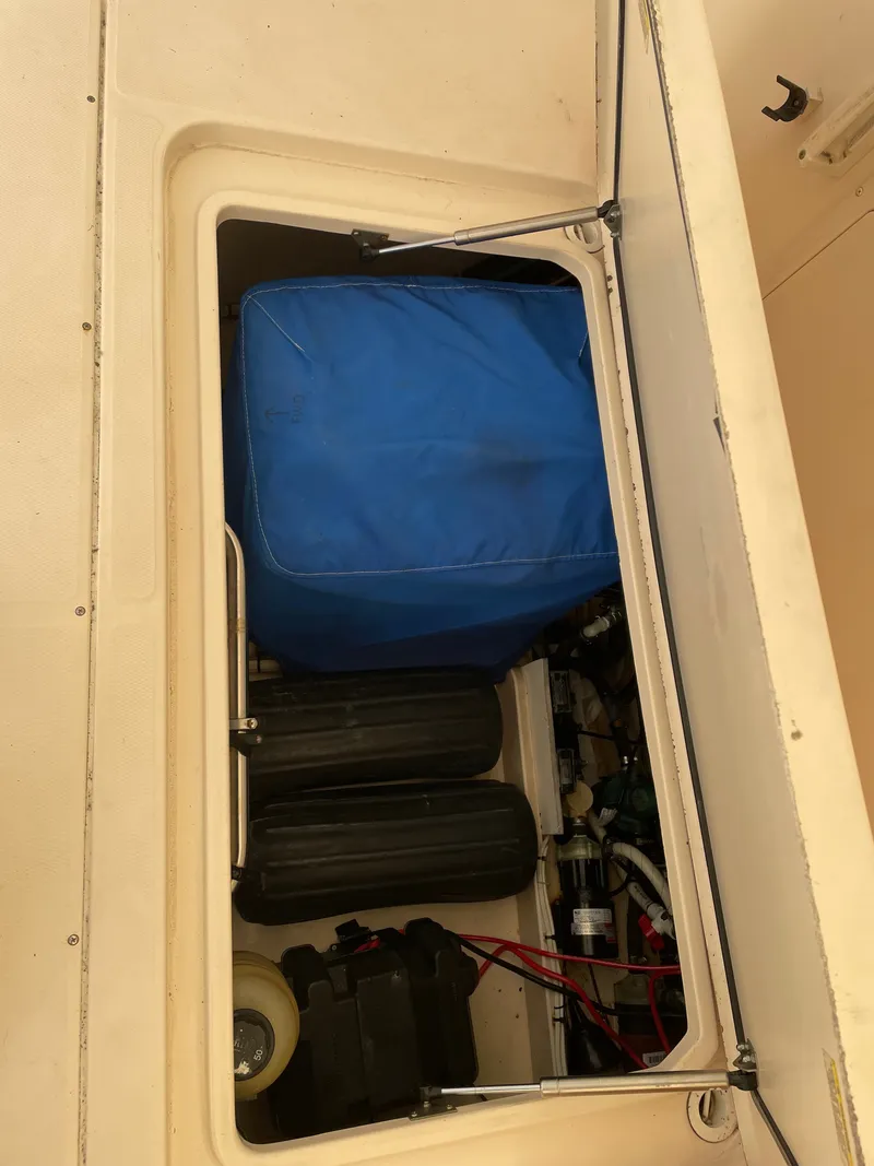 Slide: The Image of A storage compartment with a blue cover and equipment inside a boat. - 19