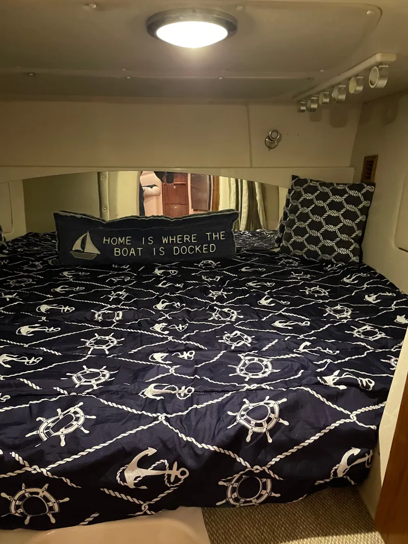 Slide: The Image of Cabin with nautical decor, anchor and wheel pattern on bedding, pillow with boating quote. - 15