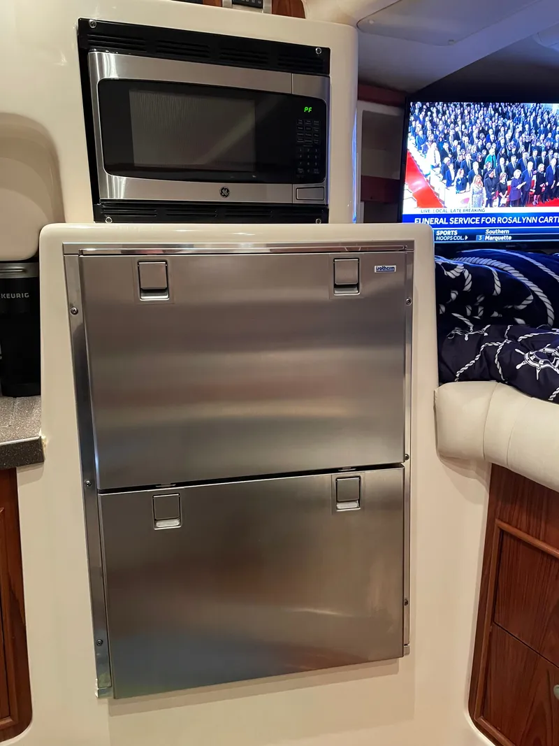 Slide: The Image of The cabin of a 2005 Grady-White Express 360 features a microwave and a refrigerator. - 8