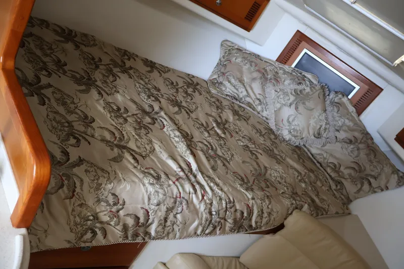 Slide: The Image of Cabin with patterned bed and pillows, wood accents, and a small window. - 15