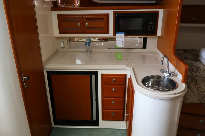 Slide: The Image of The 2001 Cabo 35 Express galley features a fridge, sink, and microwave. - 18