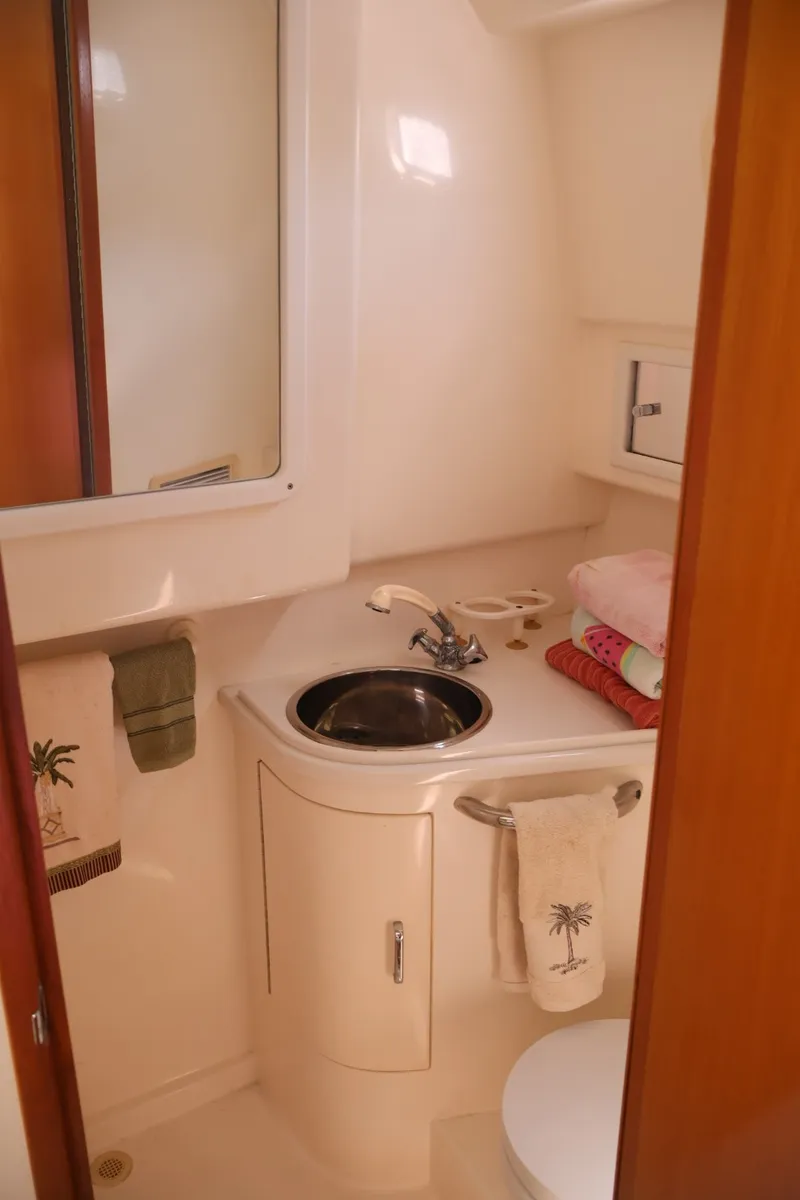 Slide: The Image of The image shows a compact boat bathroom with a sink, mirror, and towels. - 21