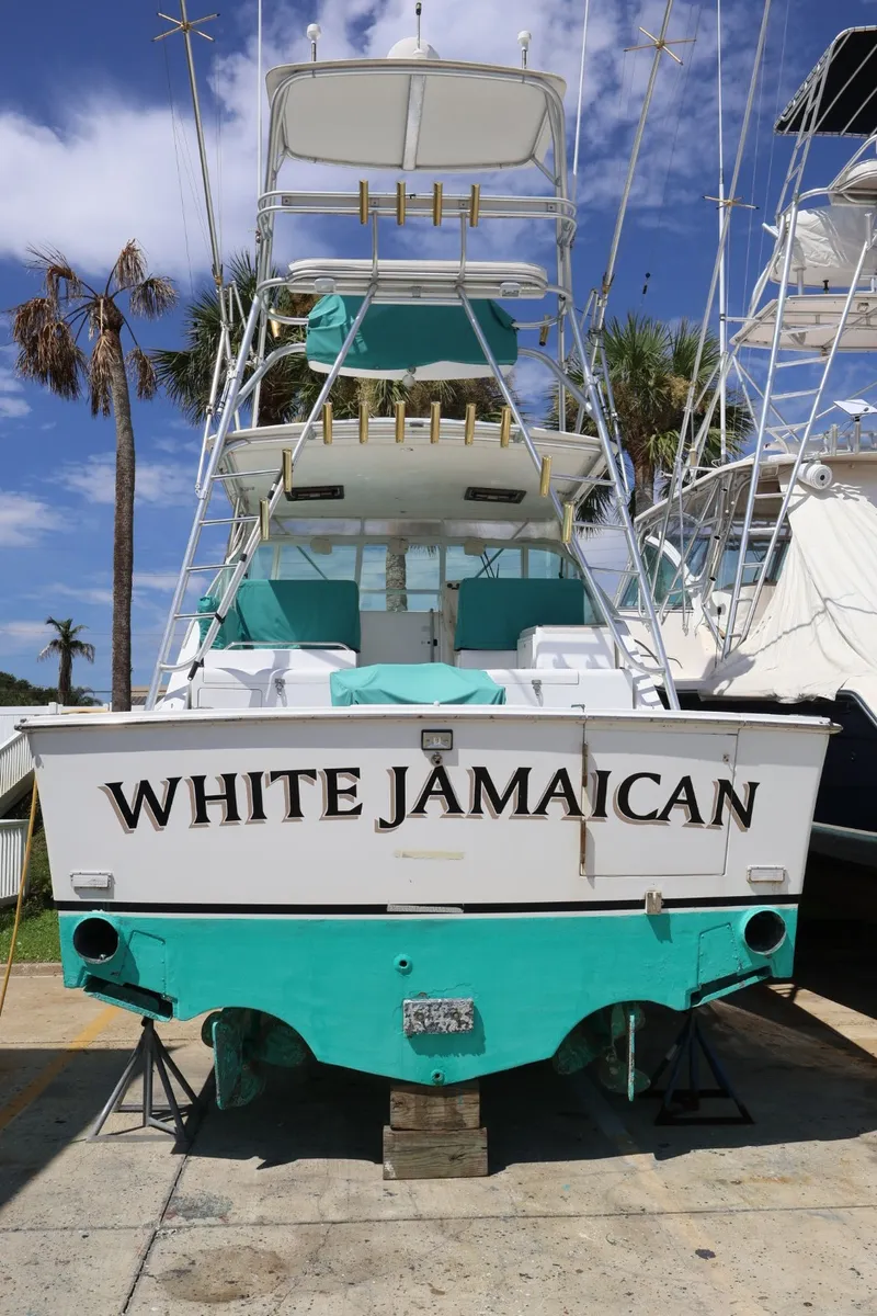 Slide: The Image of Cabo 35 Express 2001 with turquoise accents and the name "White Jamaican" on the stern. - 2
