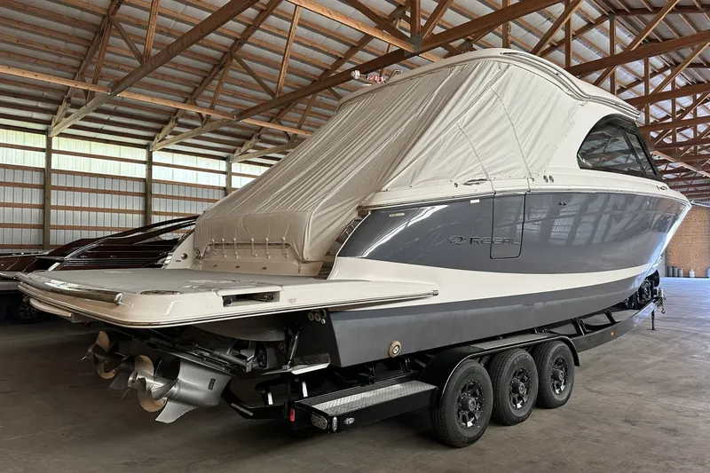 Slide: The Image of 2023 Regal LS36 boat in storage, featuring sleek design and triple-axle trailer. - 1