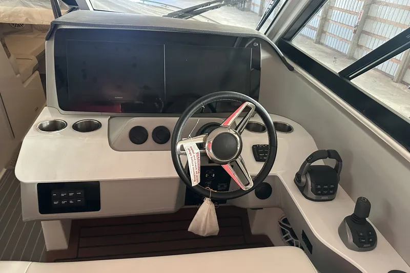 Slide: The Image of 2023 Regal LS36 boat helm with steering wheel, controls, and cup holders. - 5
