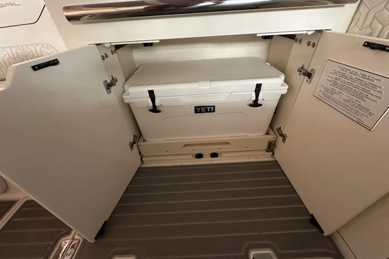 Slide: The Image of 2023 Regal LS36 boat storage with Yeti cooler inside open compartment. - 11