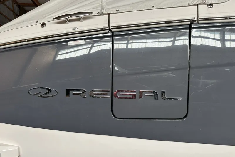 Slide: The Image of 2023 Regal LS36 boat with logo, docked indoors under a cover. - 25