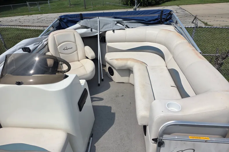 Slide: The Image of 2007 Quest mini pontoon boat interior with white seating and steering console. - 4