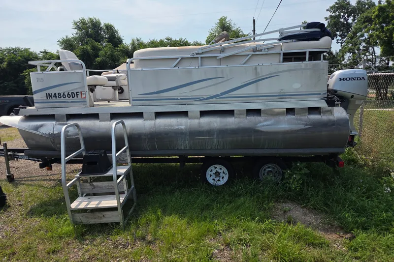 Slide: The Image of 2007 Quest mini pontoon boat on trailer with Honda outboard motor. - 2