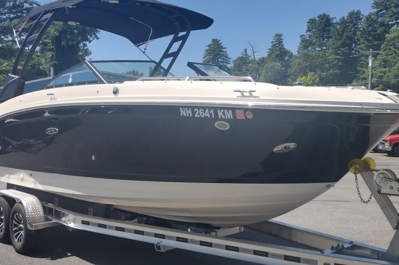 Slide: The Image of 2023 Sea Ray SDX 270 boat on trailer, parked outdoors with trees in background. - 3