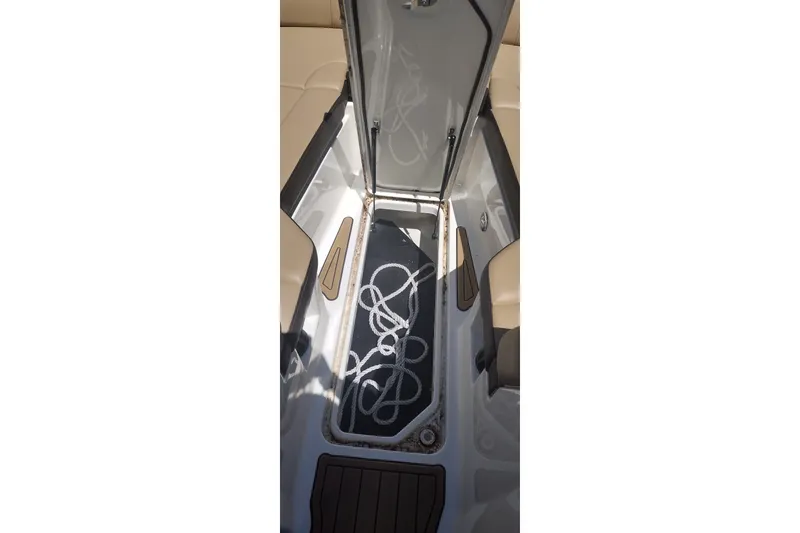 Slide: The Image of 2023 Sea Ray SDX 270 boat storage compartment with rope, featuring beige seating. - 48
