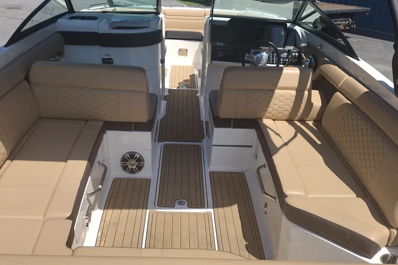 Slide: The Image of 2023 Sea Ray SDX 270 boat interior with tan seating and wood flooring. - 14