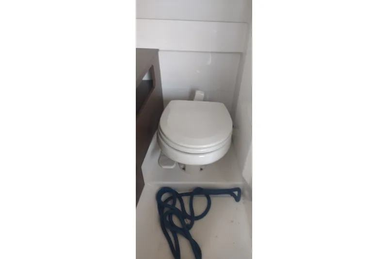 Slide: The Image of Marine toilet in 2023 Sea Ray SDX 270 boat interior, with coiled rope nearby. - 51