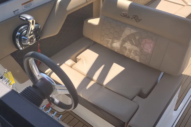 Slide: The Image of 2023 Sea Ray SDX 270 boat interior with steering wheel and beige seating. - 24