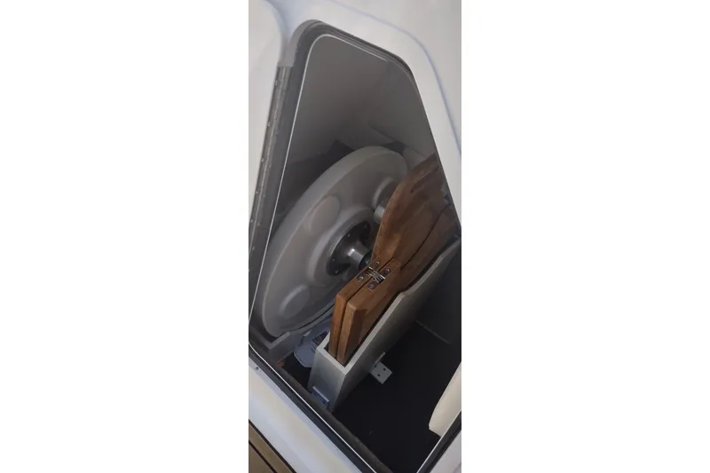Slide: The Image of Storage compartment in 2023 Sea Ray SDX 270 boat, featuring a wooden table and life ring. - 47
