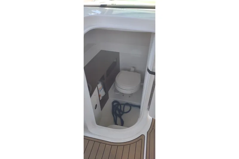 Slide: The Image of 2023 Sea Ray SDX 270 boat interior with compact marine toilet. - 49